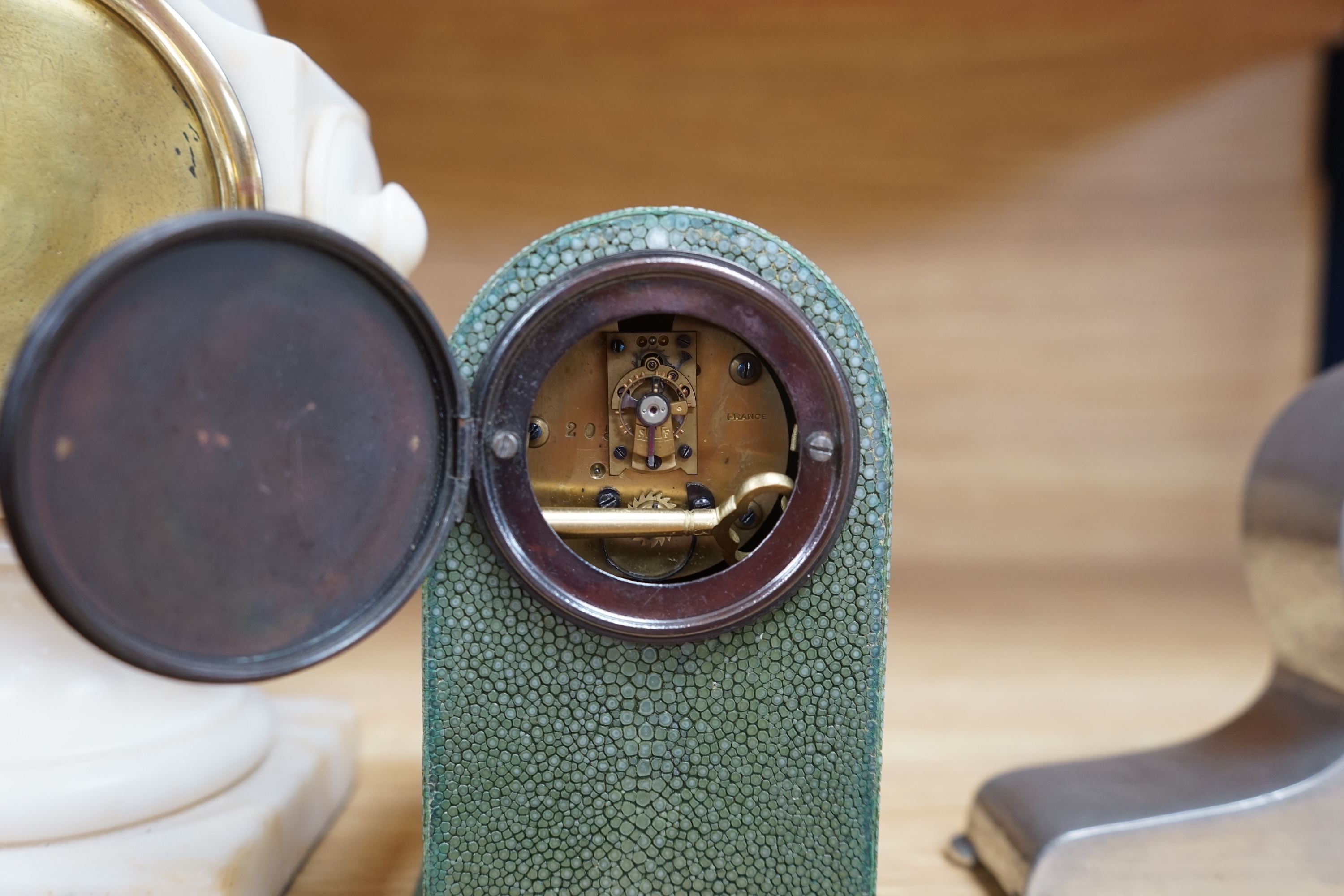 Three small mantel timepieces including a Tudric pewter timepiece, and a French timepiece in an alabaster case, signed Henry Marc, Paris. Condition - fair to good.